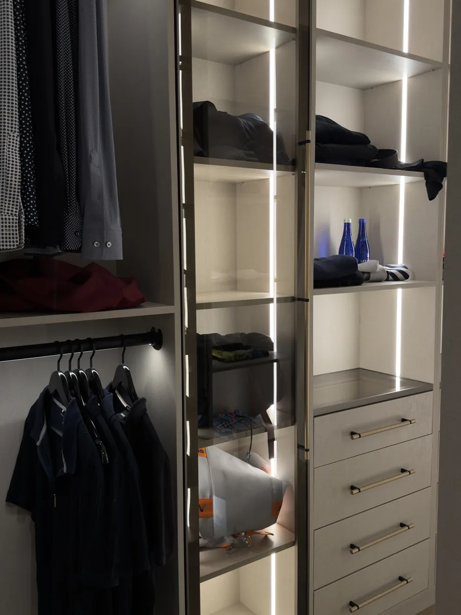 Dark wardrobe with lit glass doors, drawer bank and hanging rail