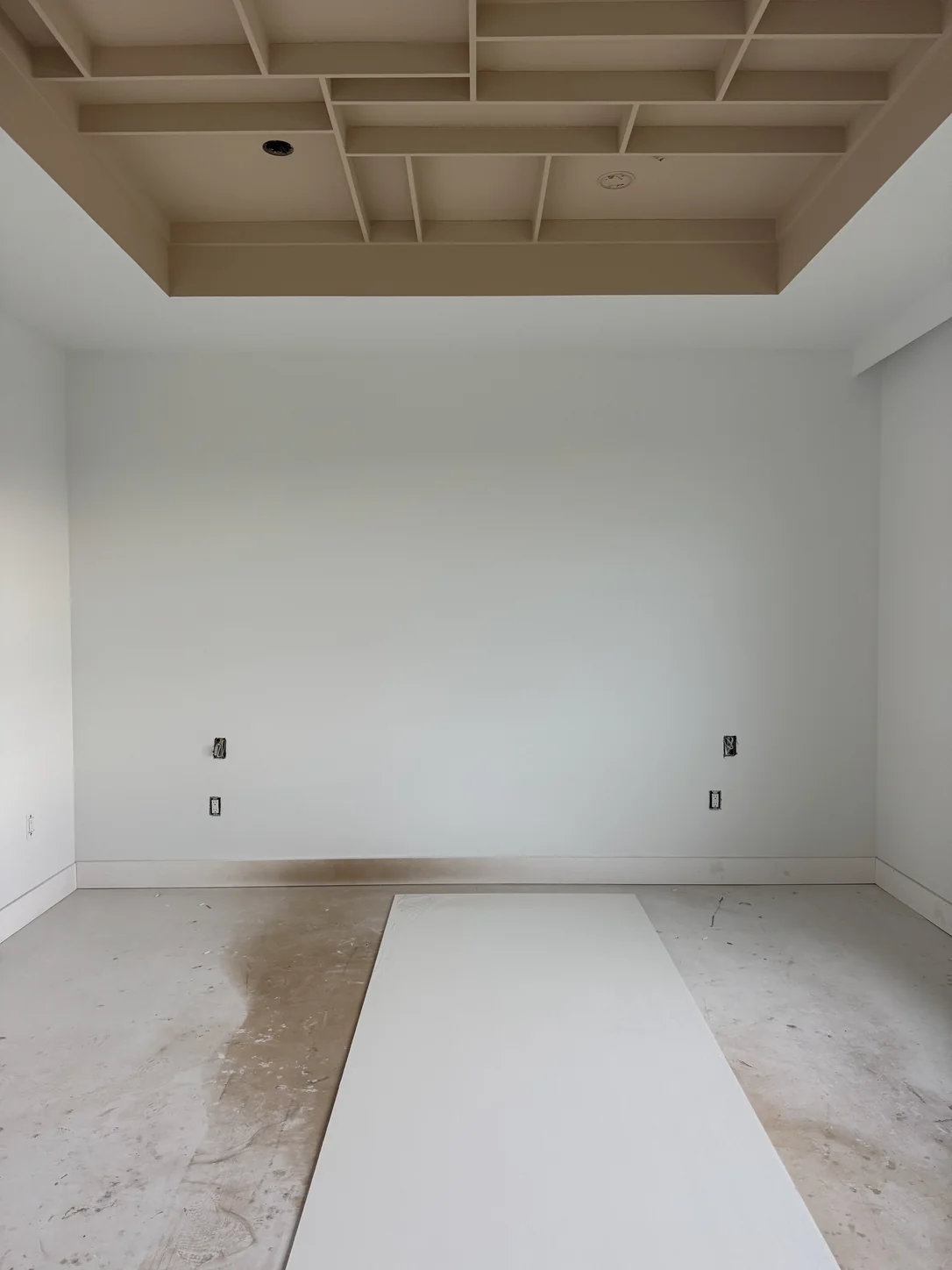 Empty bedroom with coffered ceiling and bare walls — before