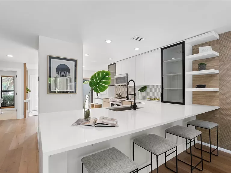 Organic Modern — white kitchen island with light oak shelving and bar stools