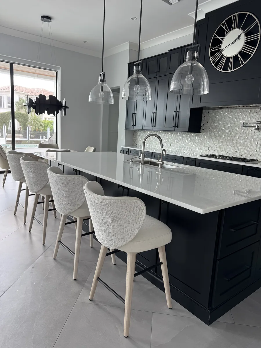 Refined Coastal — kitchen with navy cabinetry, white quartz island and pendant lights